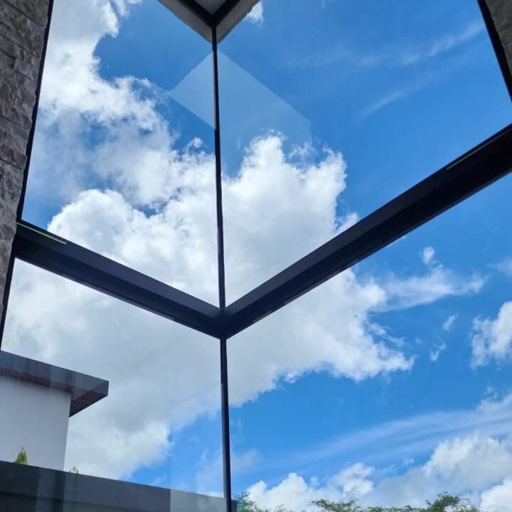 Ventanal de esquina de piso a techo con vista al cielo