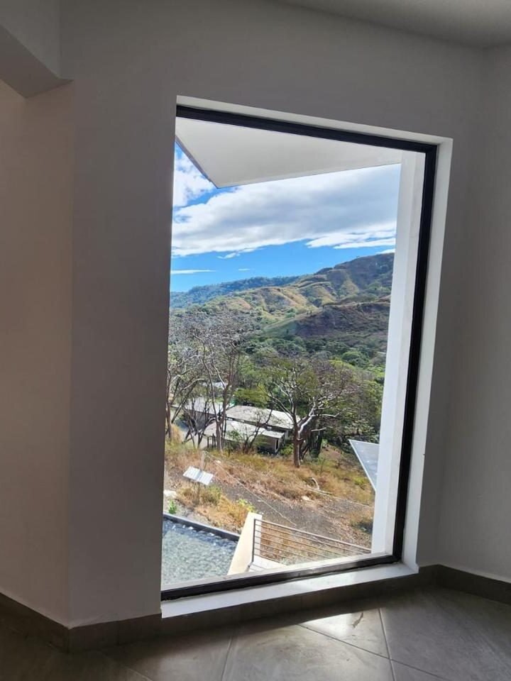 Ventana fija de piso a techo con vista a las montañas